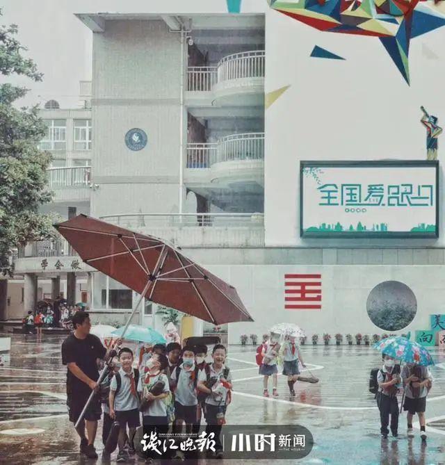 老师用米乐m6超大雨伞护送学生家长朋友圈配文：小朋友雨天的专属快乐(图1)